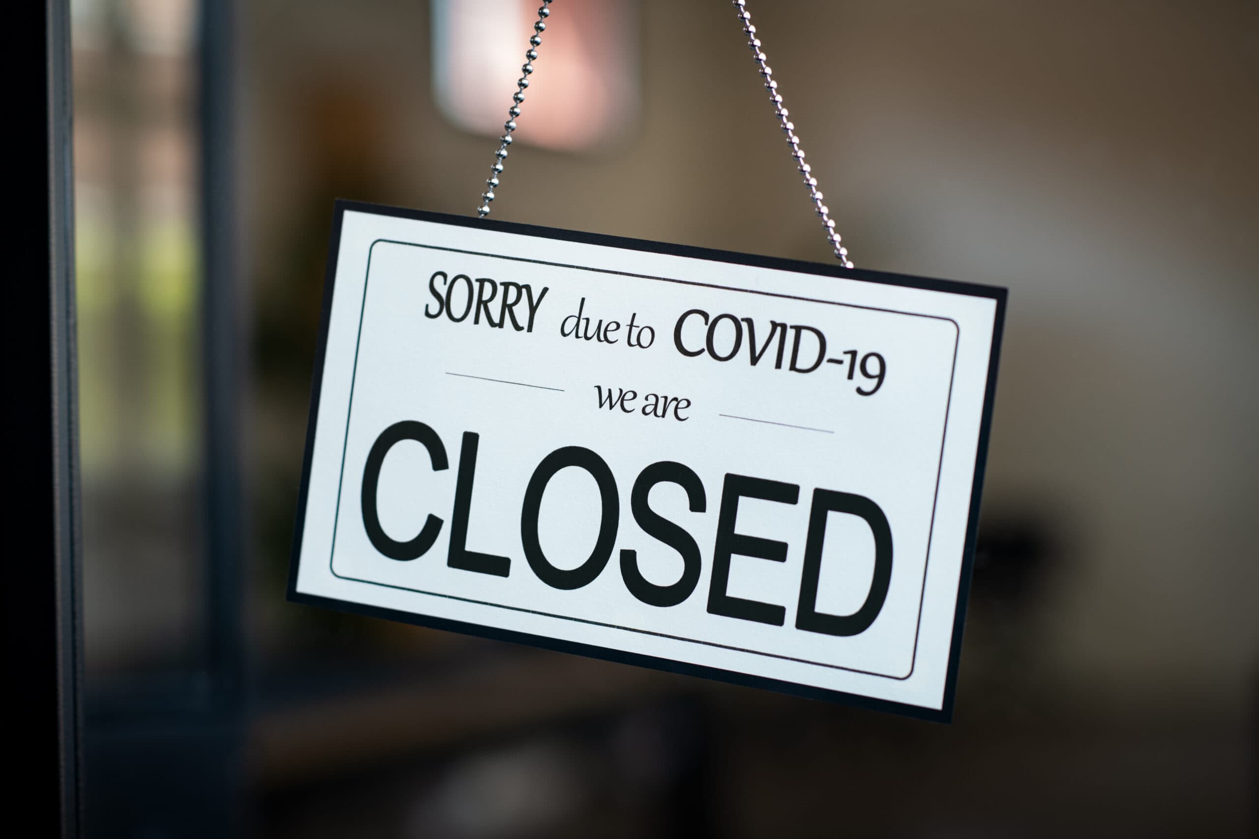 Closed sign hanging on door of cafe due to Covid-19
